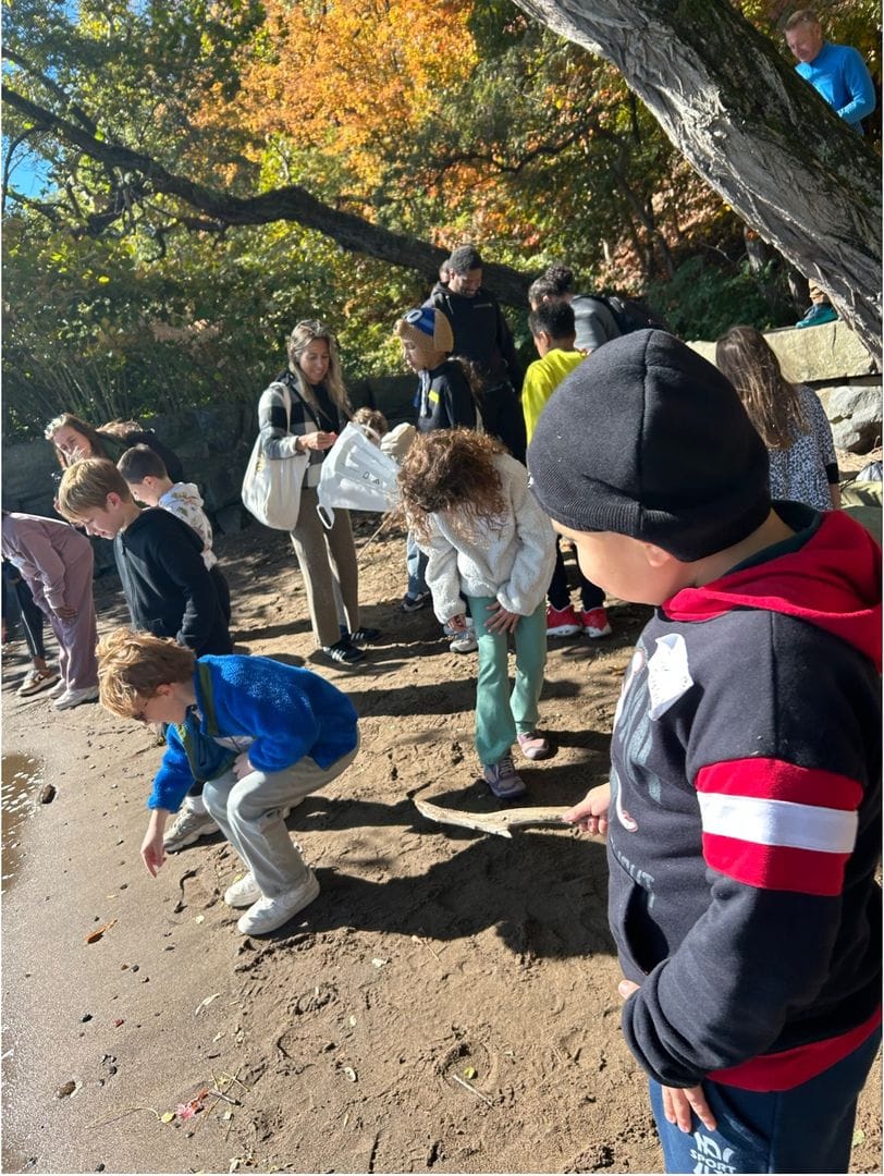 Young students explore a sandy Hudson River beach on a fall field trip