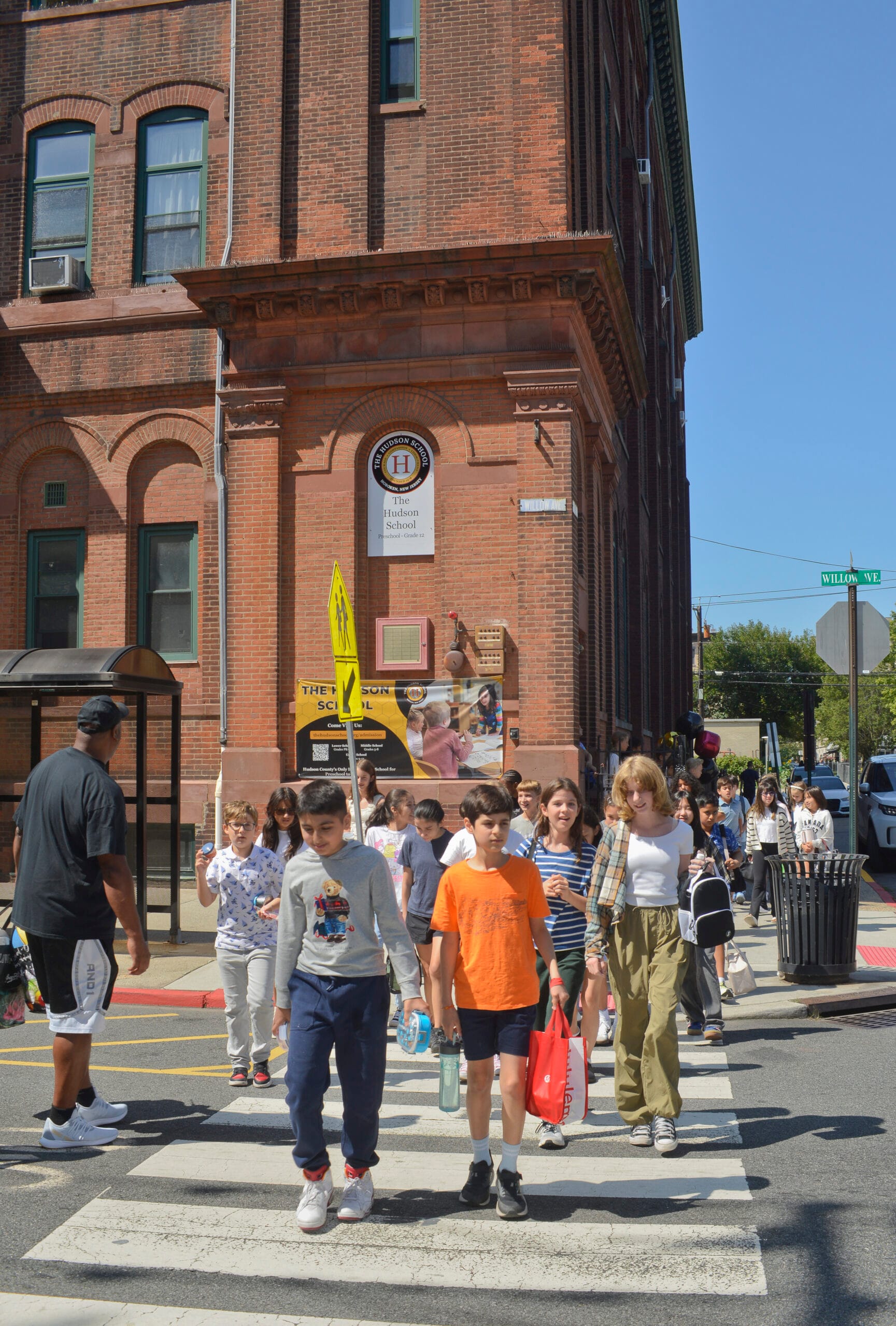 Students cross Willow Avenue outside the brick Hudson School building in Hoboken
