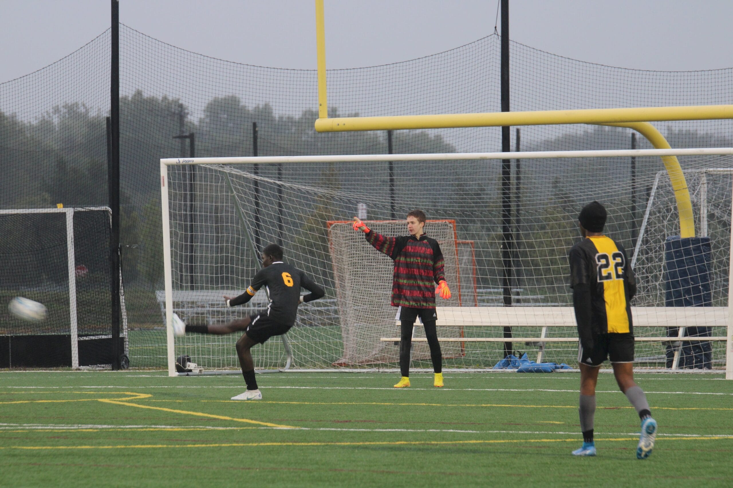 A Hudson soccer player strikes the ball toward goal as the keeper sets
