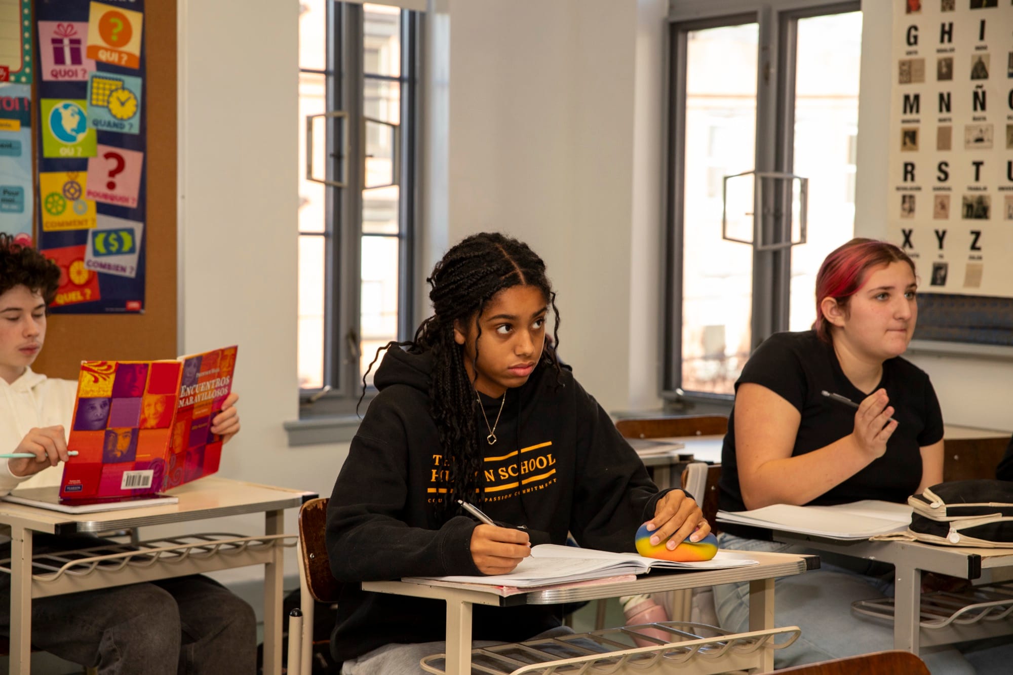 Wide bright classroom with multiple Hudson School students at their desks