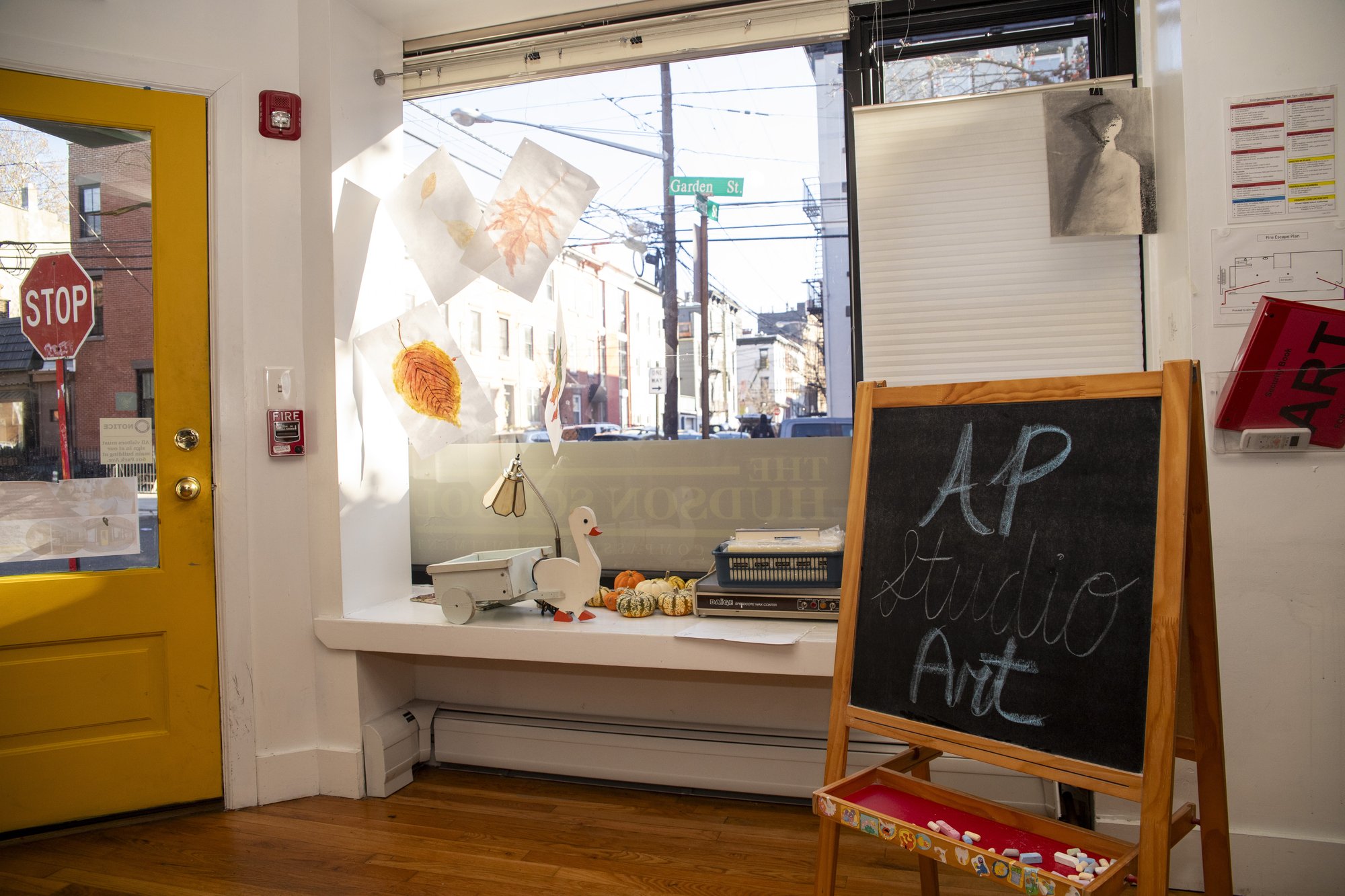 AP Studio Art easel and student artwork displayed in a sunlit street-front window