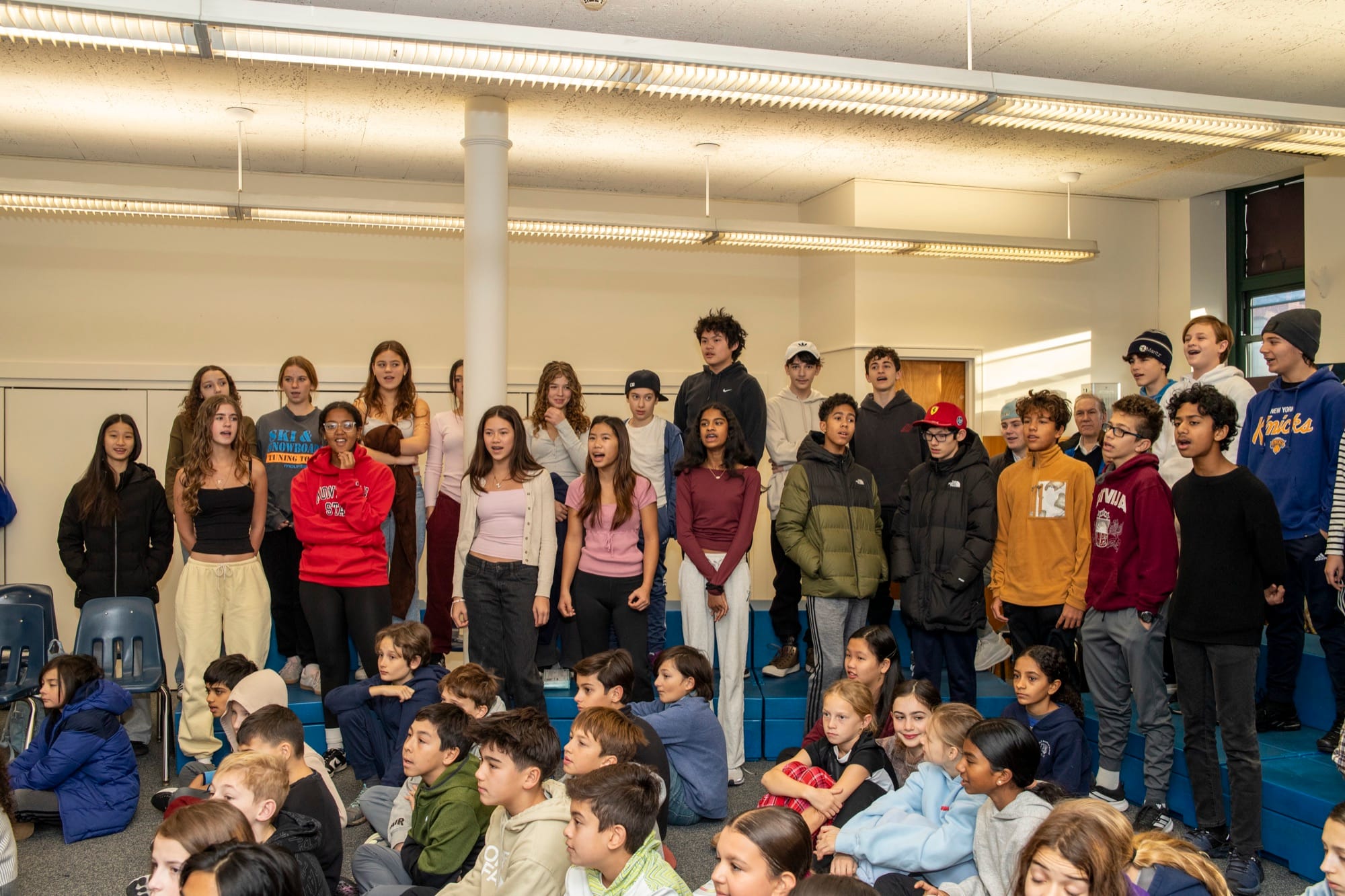 Students of varied backgrounds seated together at a Hudson School assembly