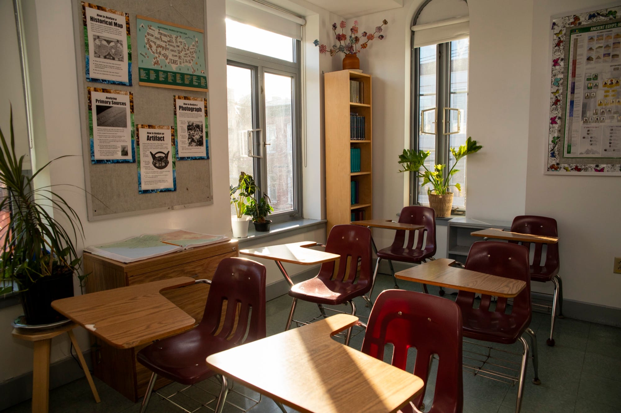 Sunlit empty classroom interior with bookshelves