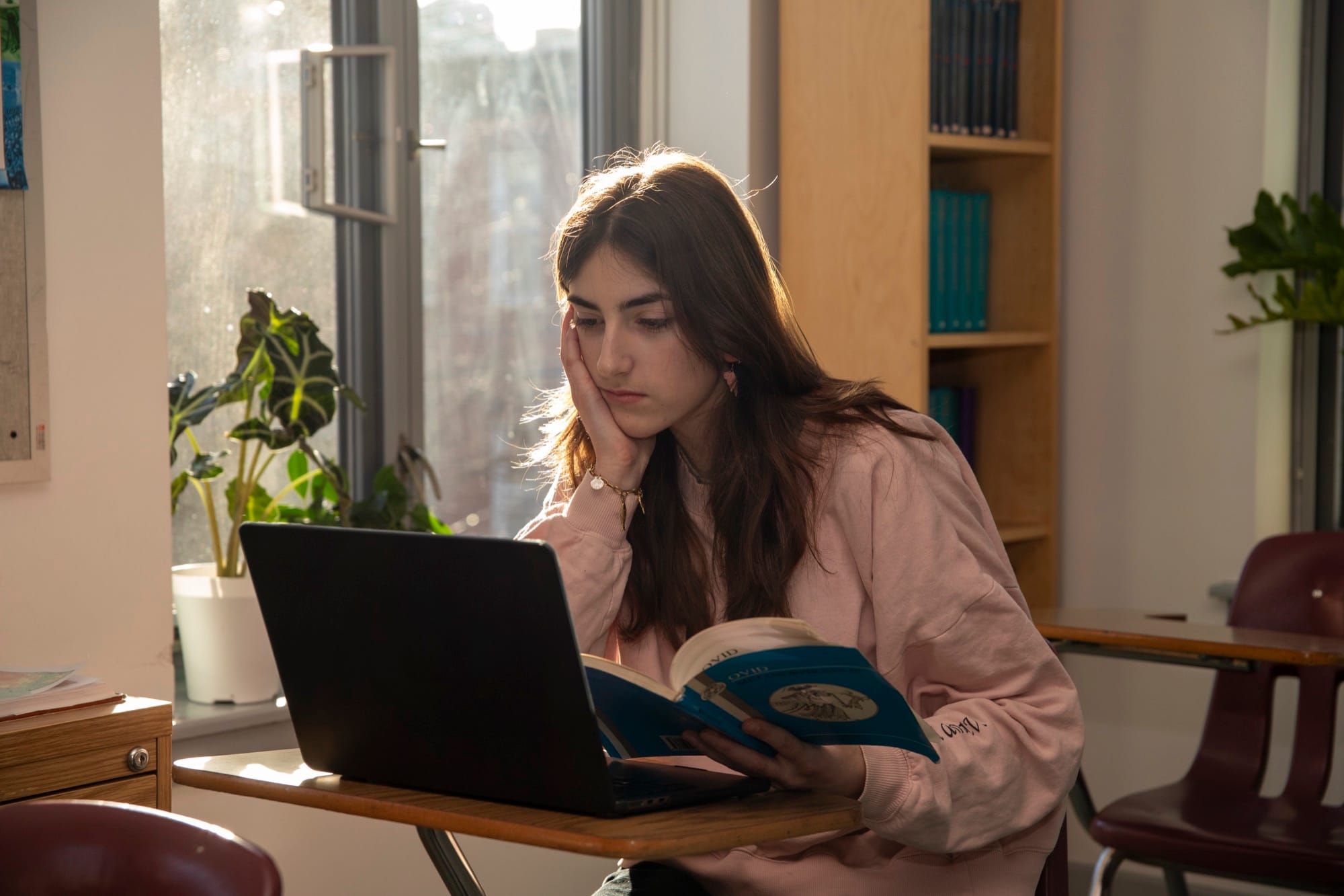 Female Hudson School student at a laptop in a warm sunlit classroom
