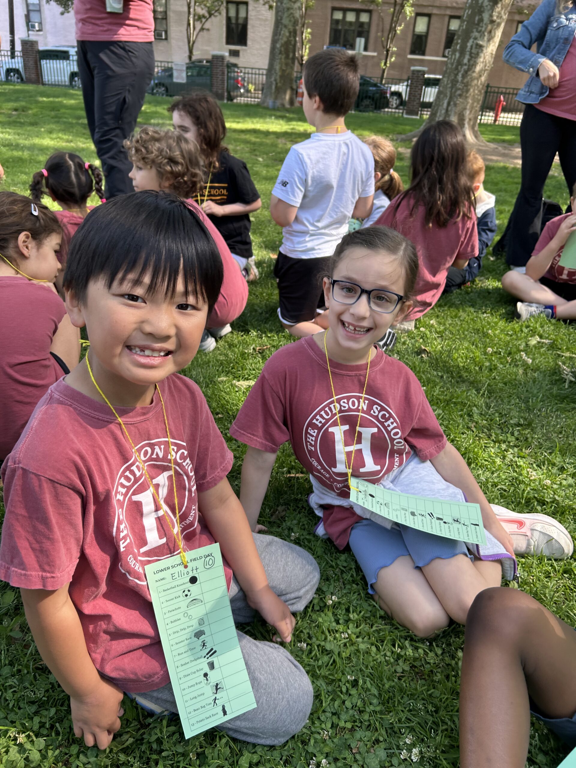 Two Lower School students show their Field Day scorecards in a Hoboken park